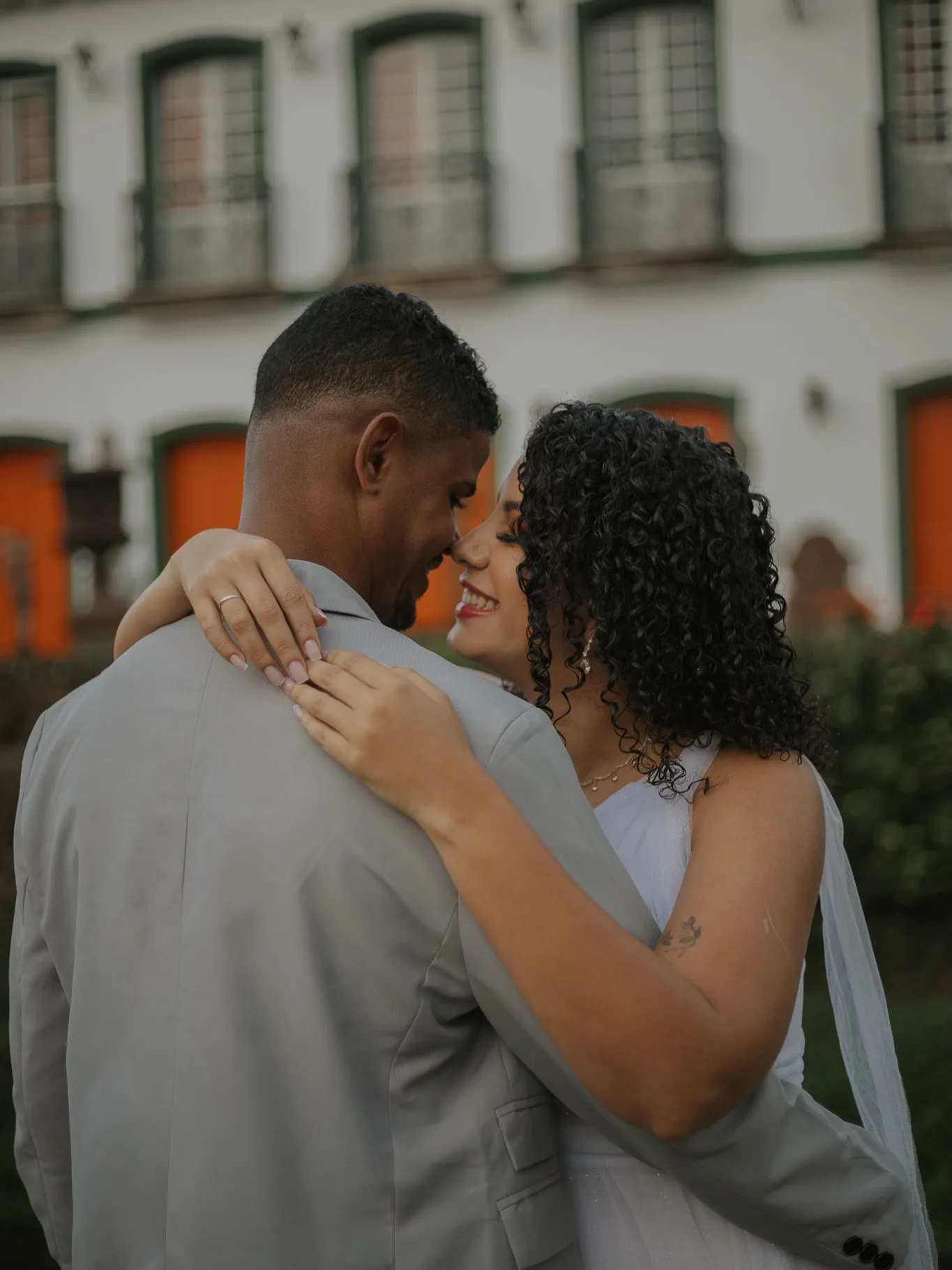 Casal abraçado, testas quase encostadas, em ensaio pré-wedding
